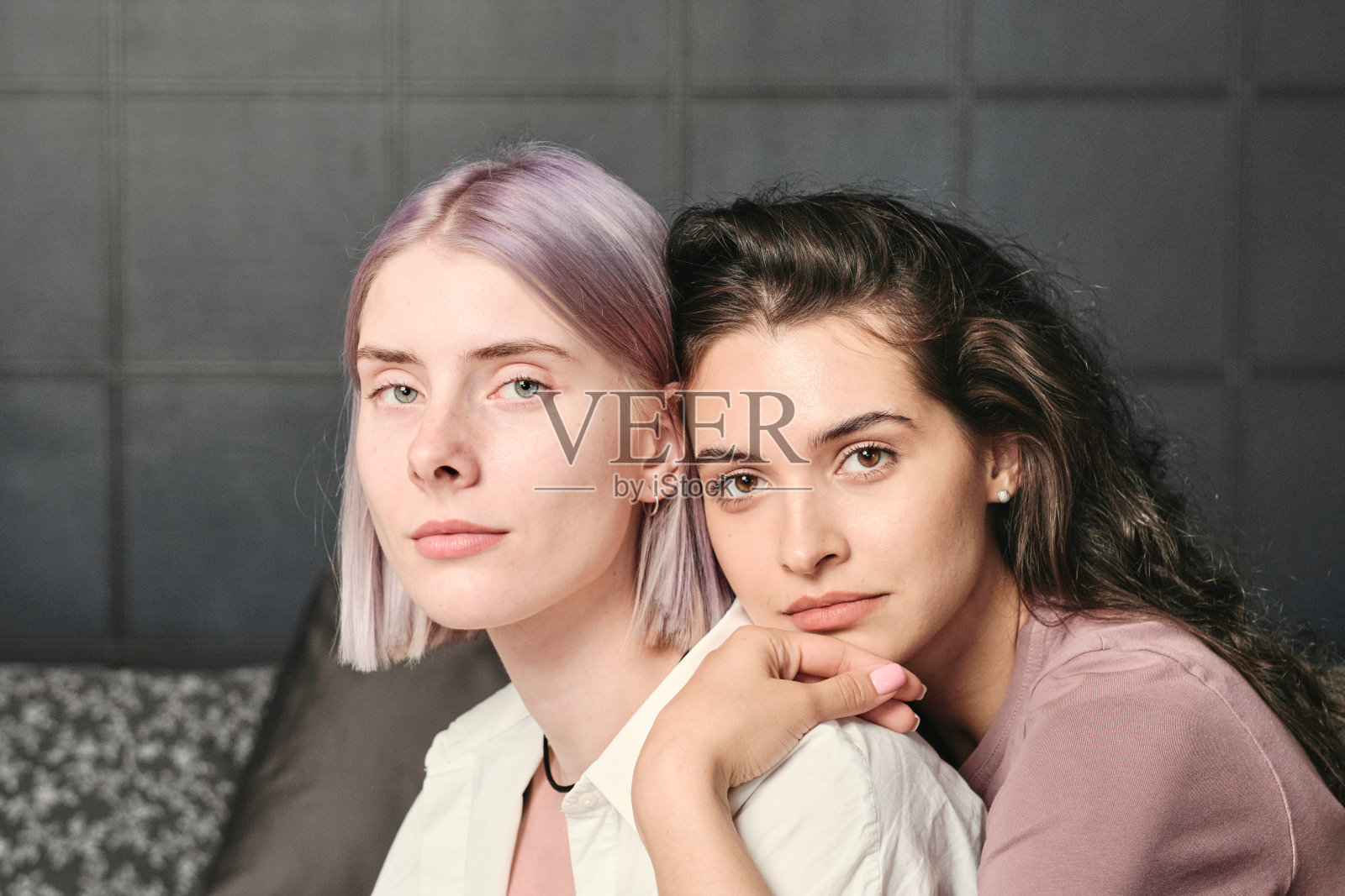 冷静的年轻棕色头发的女人靠在女朋友的肩膀上，在卧室里拥抱她照片摄影图片