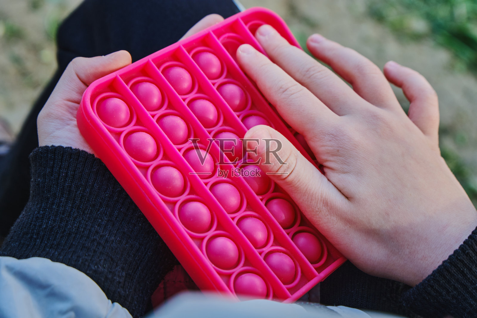 儿童手中的流行减压玩具：红色方形指尖玩具照片摄影图片