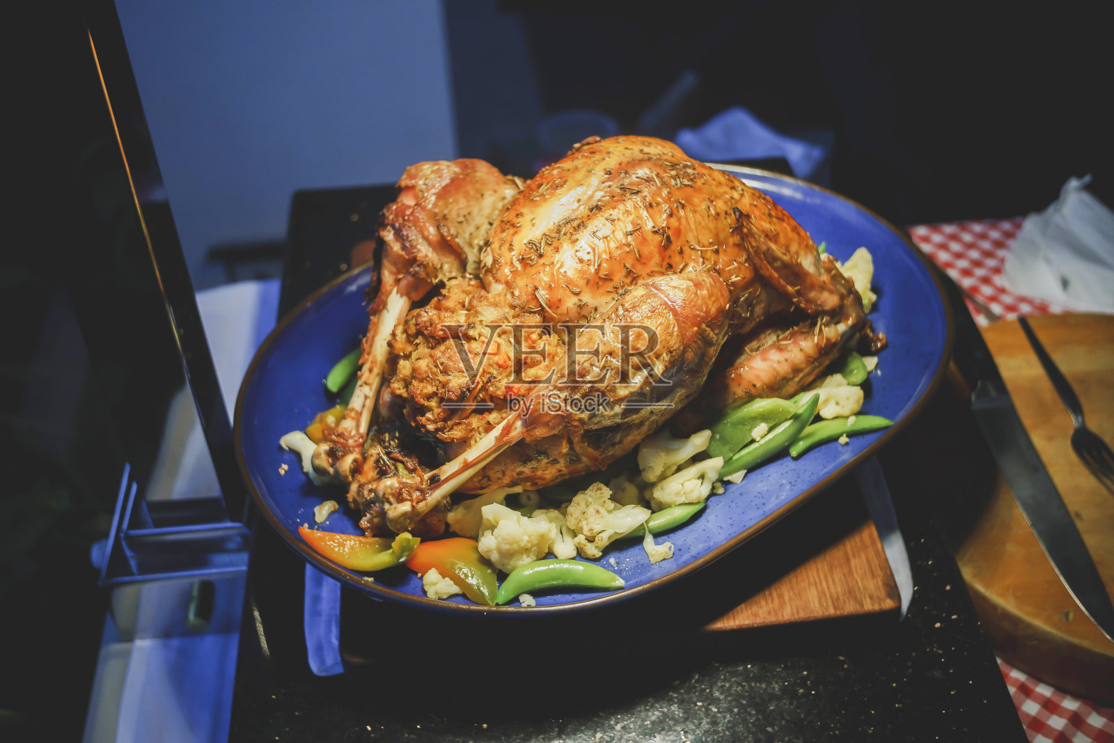 整只烤鸡配蔬菜和炸土豆放在平底锅上，颜色为木质背景照片摄影图片