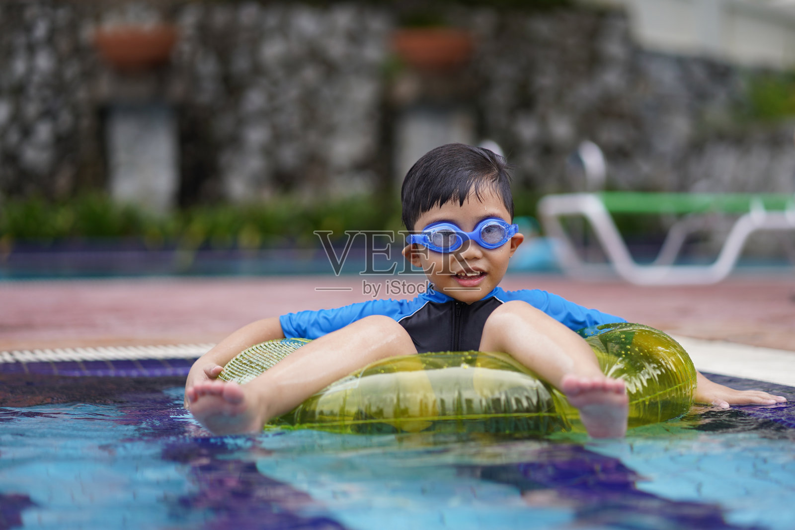 游泳池里的男孩照片摄影图片