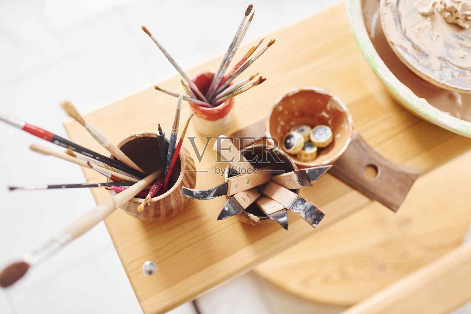 木桌上的刷子和其他陶器工具的俯视图照片摄影图片