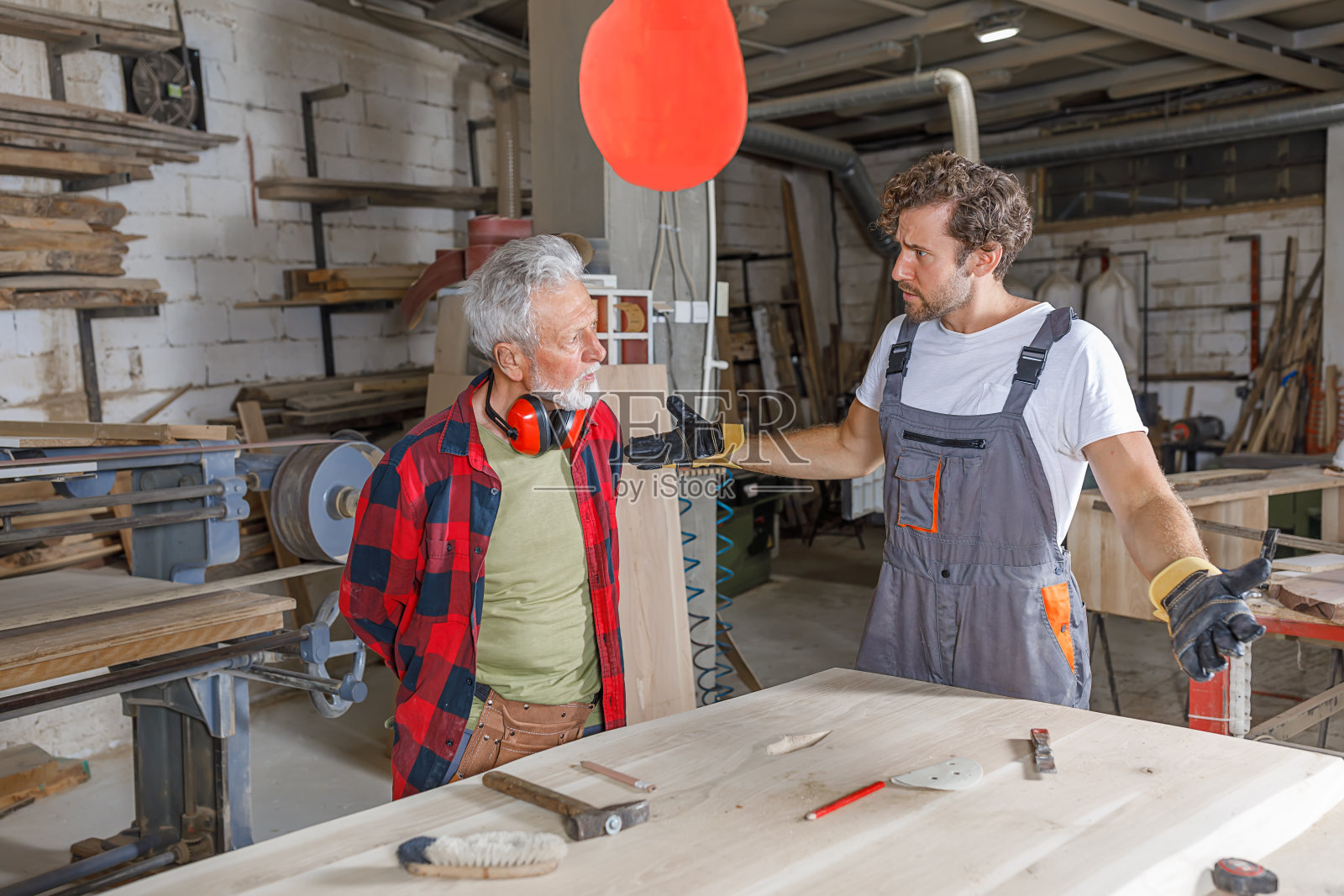 两个木匠在认真地争论木工工程。照片摄影图片
