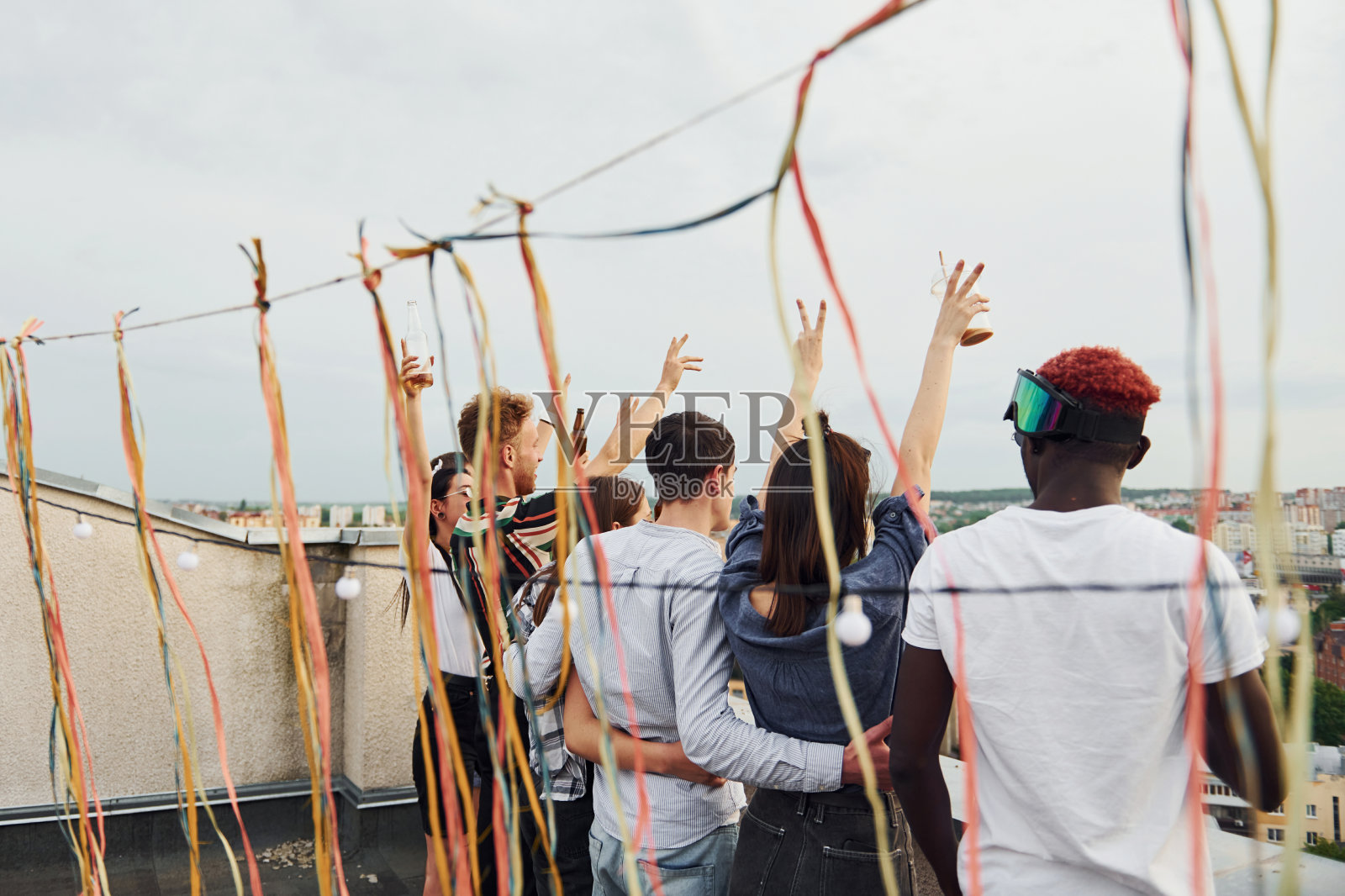 装饰的地方。多云的天气。一群穿着便服的年轻人白天一起在屋顶聚会照片摄影图片