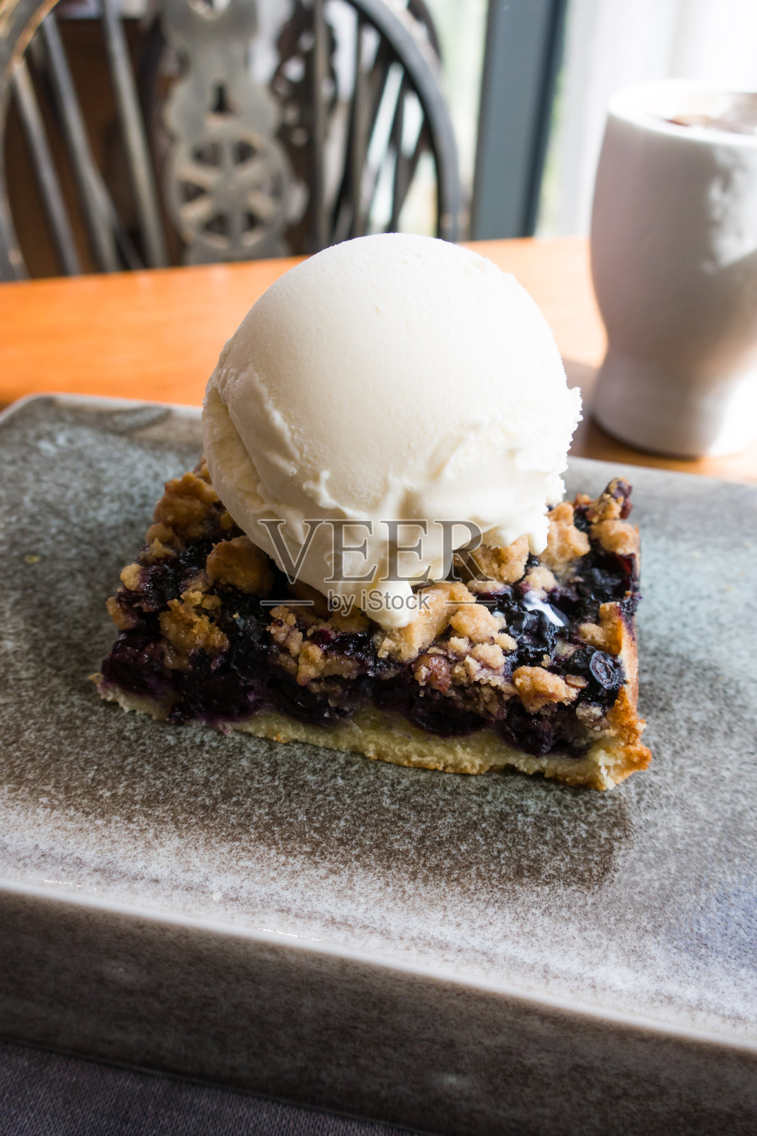 蓝莓酥粒加一勺香草冰淇淋。照片摄影图片