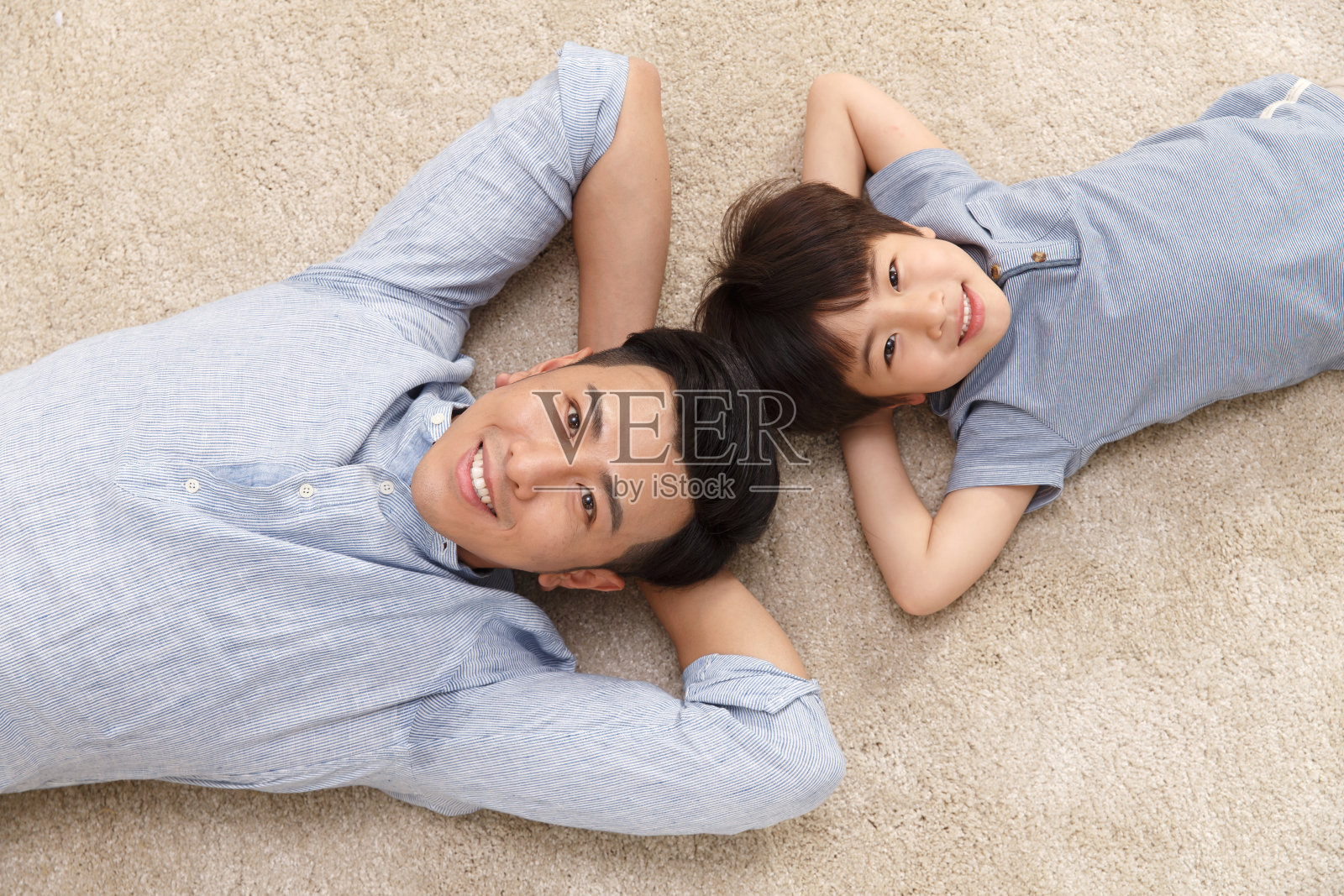 快乐的父子躺着地上照片摄影图片