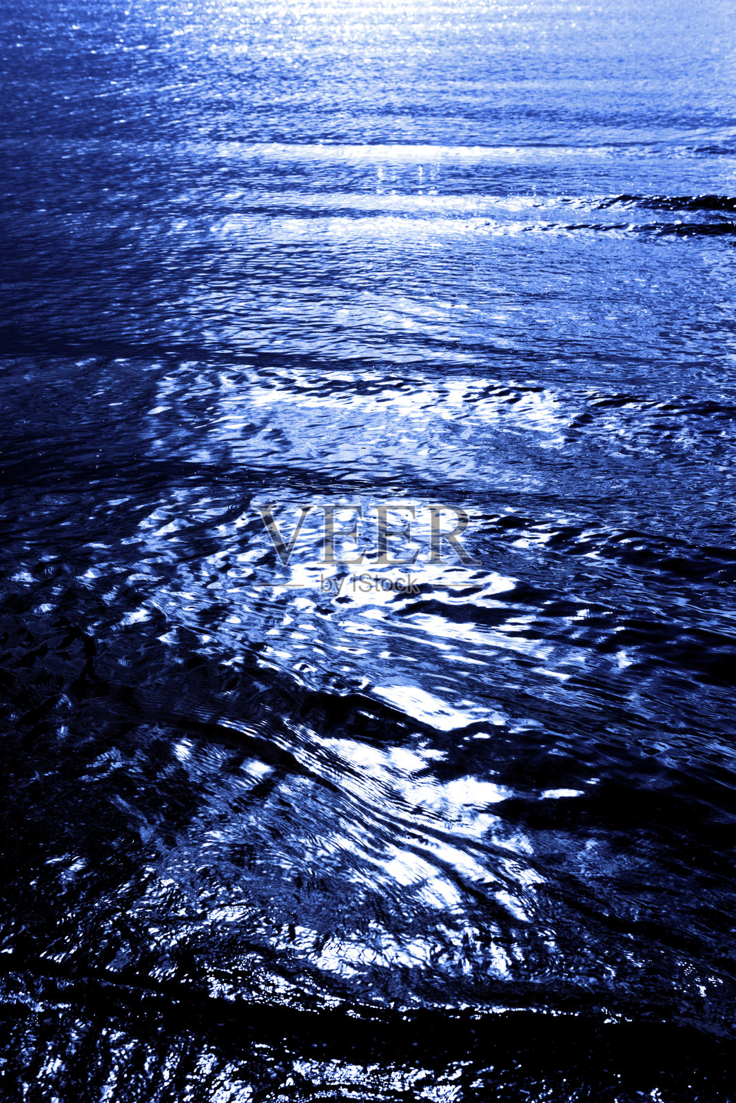 蓝色海面上月光的倒影。照片摄影图片