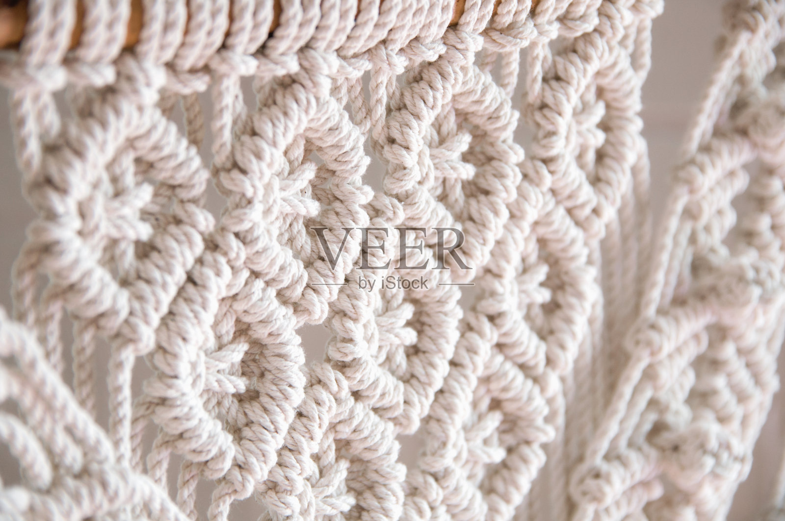 手工流苏100棉墙装饰用木棒。室内的现代装饰。照片摄影图片