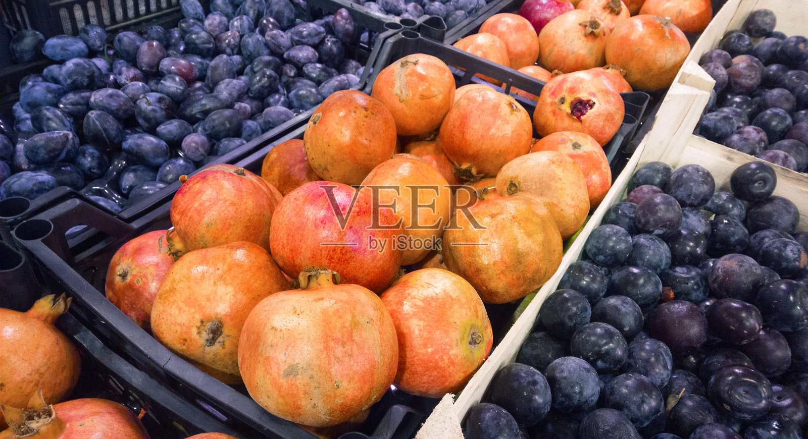 市场上的李子和石榴照片摄影图片