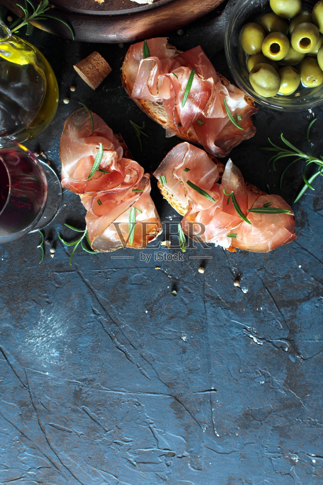 意式烤面包配意大利夏巴塔面包、橄榄油和意大利熏火腿。照片摄影图片