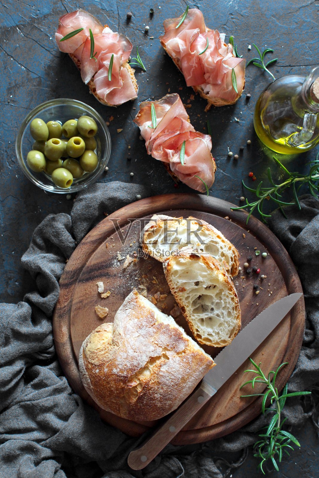 意式烤面包配意大利夏巴塔面包、橄榄油和意大利熏火腿。照片摄影图片