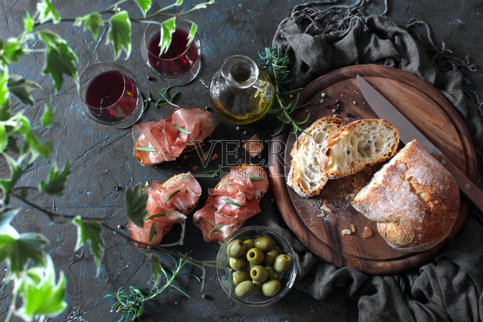 意式烤面包配意大利夏巴塔面包、橄榄油和意大利熏火腿。照片摄影图片