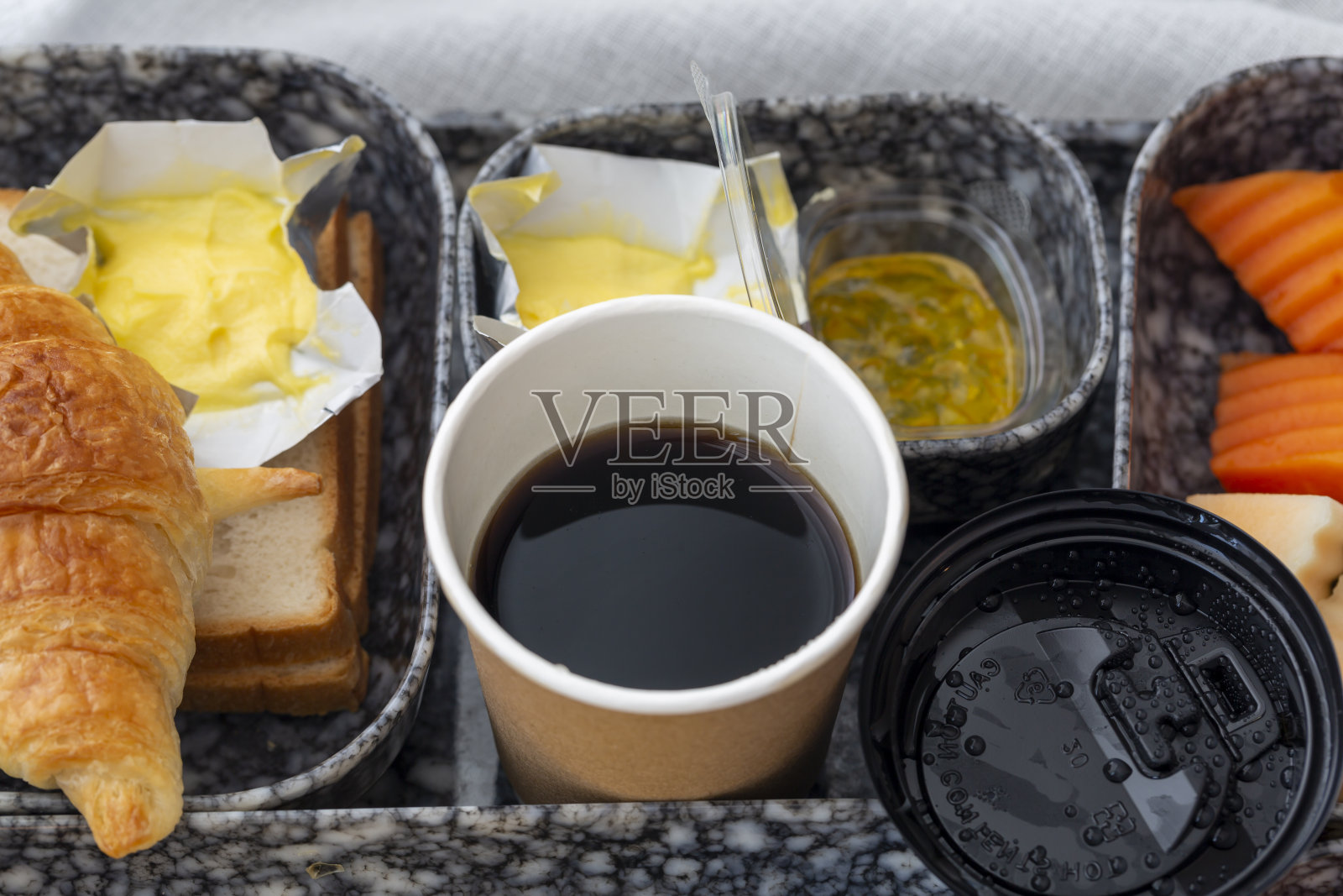 早餐包括羊角面包、蔬菜、鸡蛋、火腿、香肠、新鲜水果和咖啡照片摄影图片