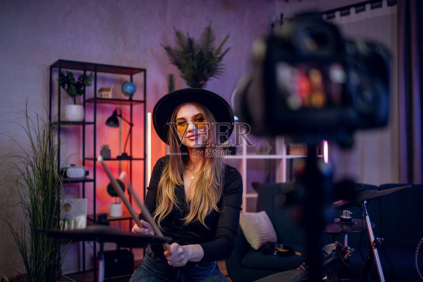 年轻女子在网上做打鼓教程照片摄影图片