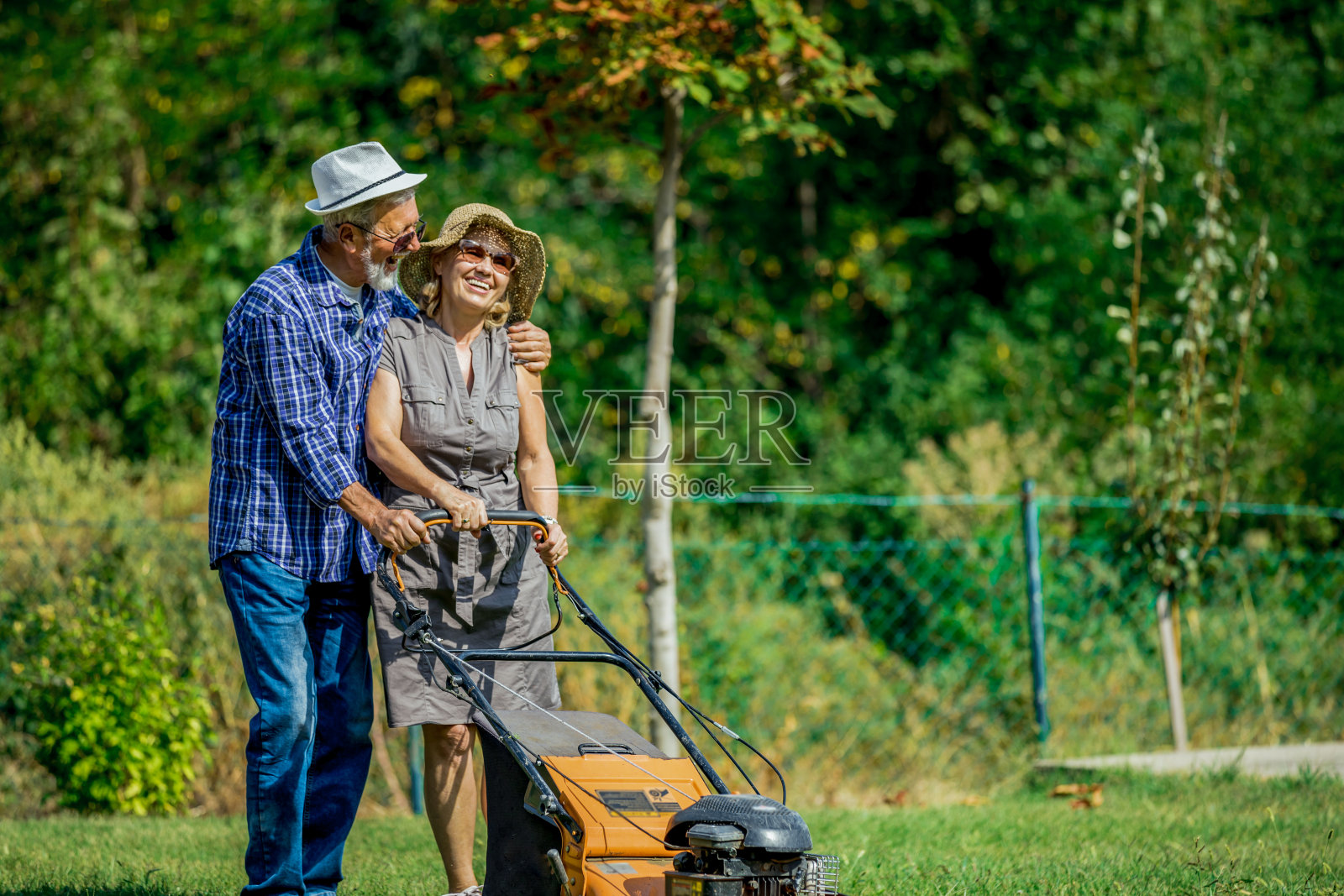男人和女人用割草机在一个乡村花园工作照片摄影图片