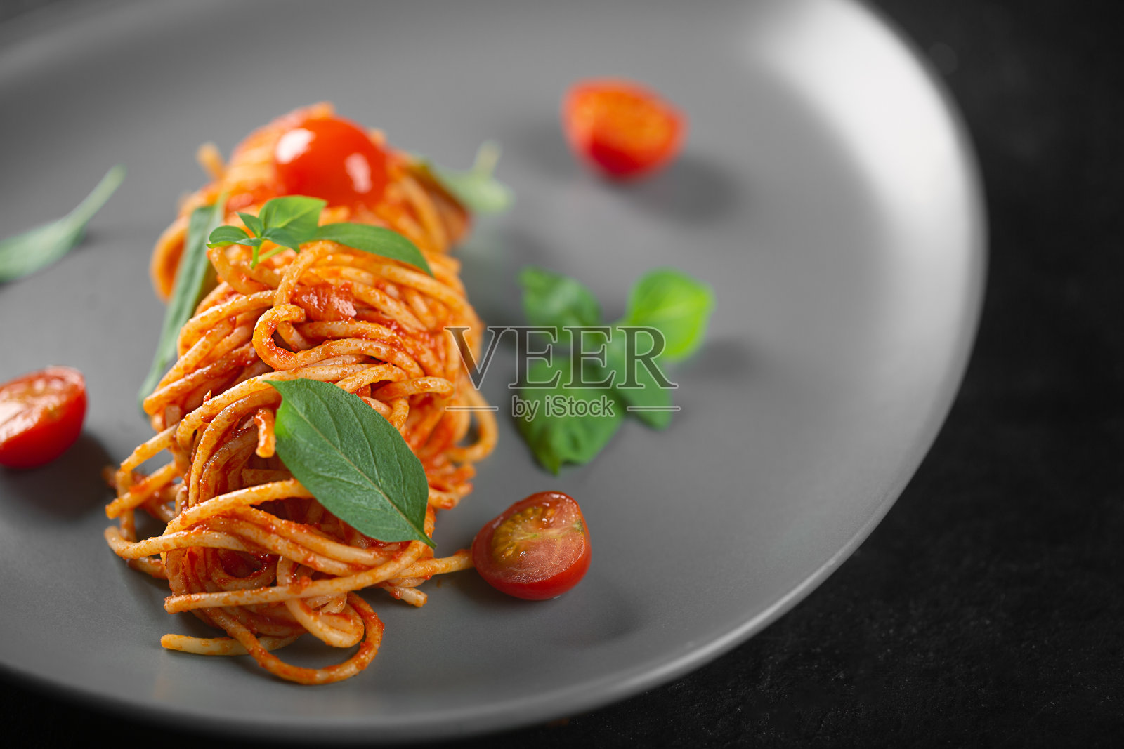 餐厅的一道菜，灰色盘子里的番茄酱意面照片摄影图片
