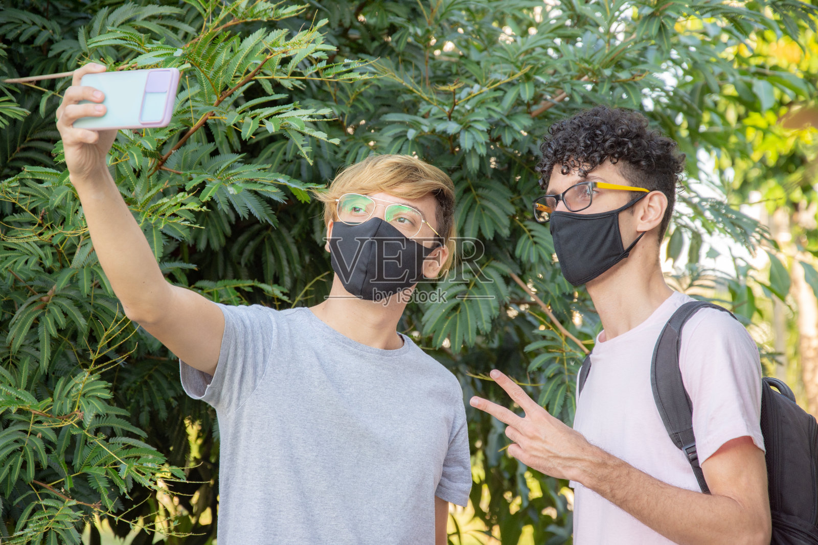 两个朋友在公园里用手机自拍照片摄影图片