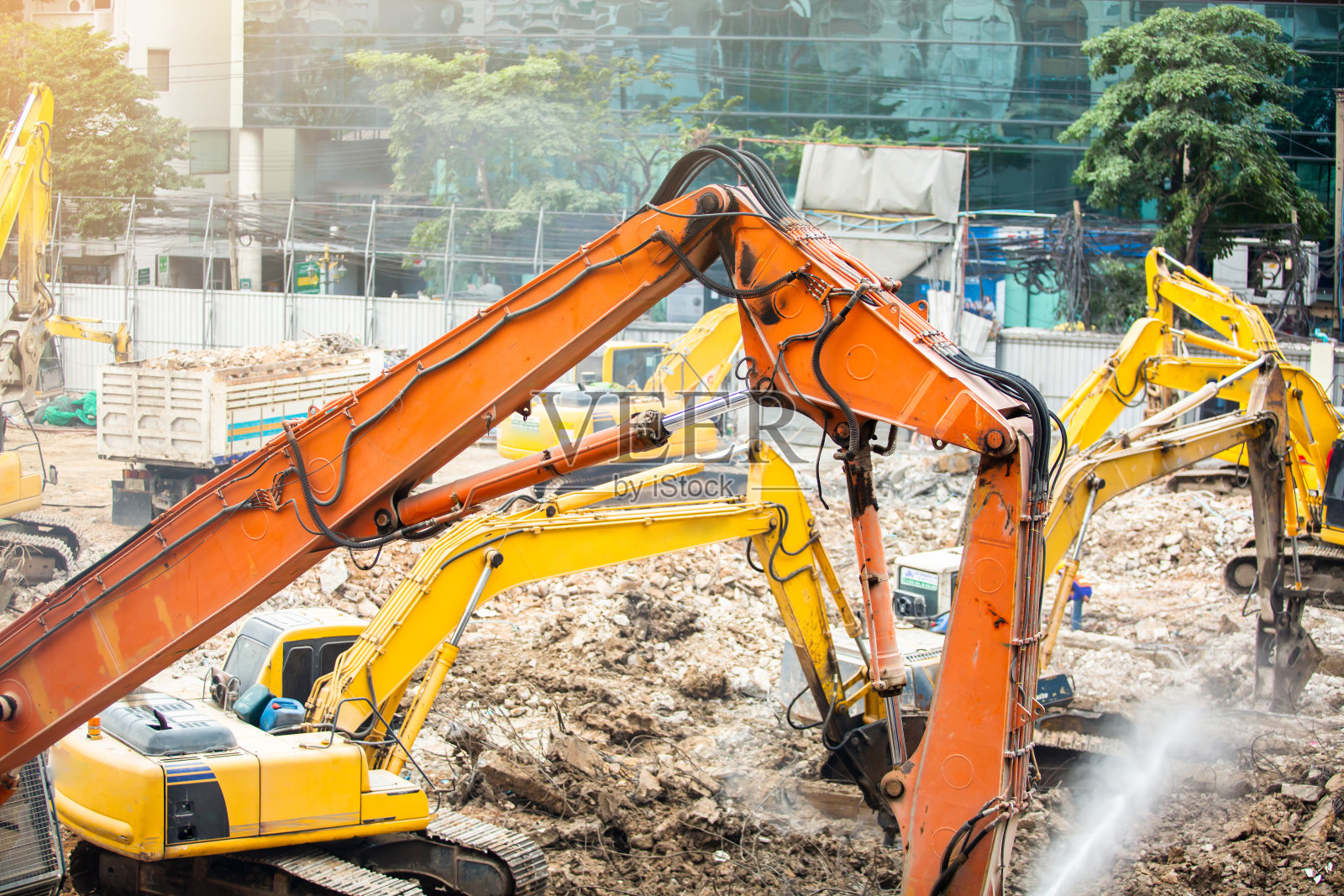 拆除起重机拆除建筑物。手提钻、挖掘机、割刀拆除旧建筑。照片摄影图片