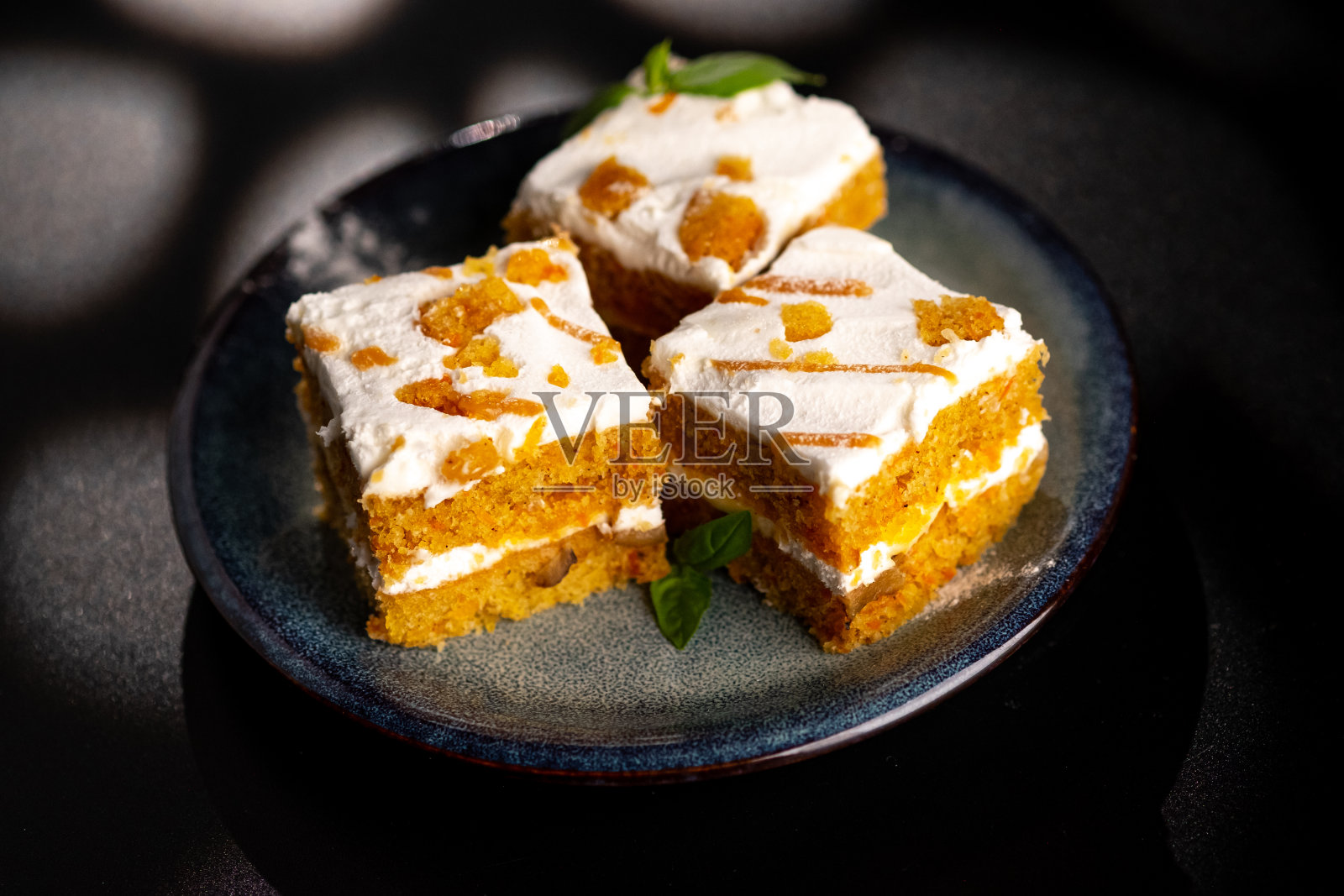 胡萝卜甜点蛋糕盘上的黑色背景。照片摄影图片