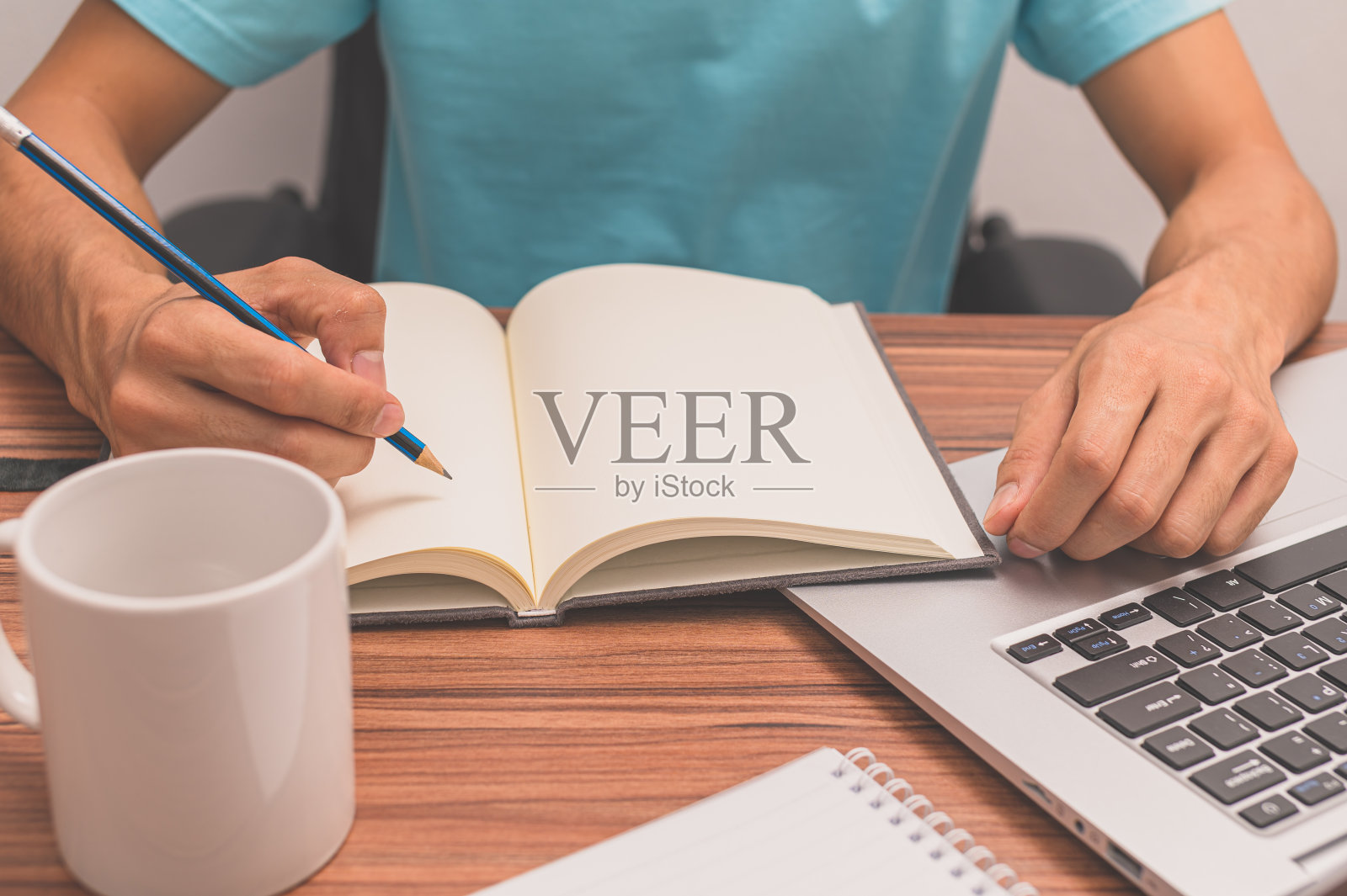 在书桌上写书的人照片摄影图片