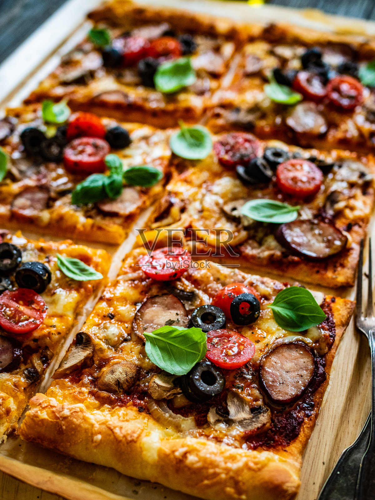 美味的玛格丽塔披萨与火腿，白蘑菇，马苏里拉奶酪和蔬菜在木制背景照片摄影图片