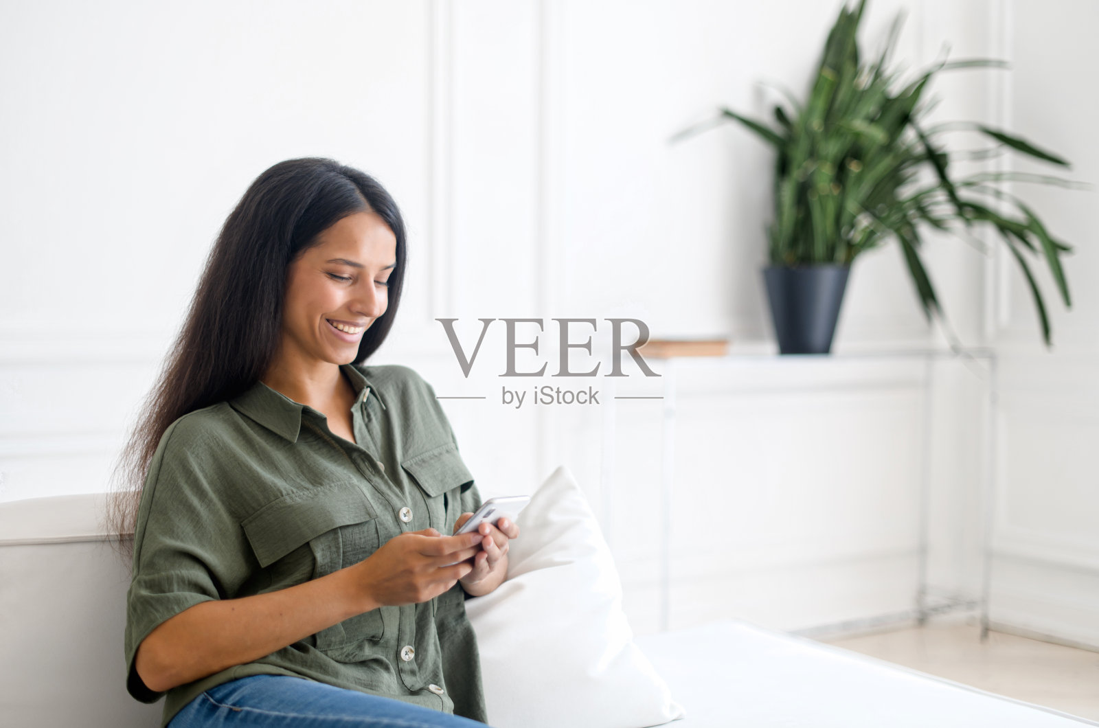 迷人开朗的印度女人拿着智能手机独自在家放松照片摄影图片