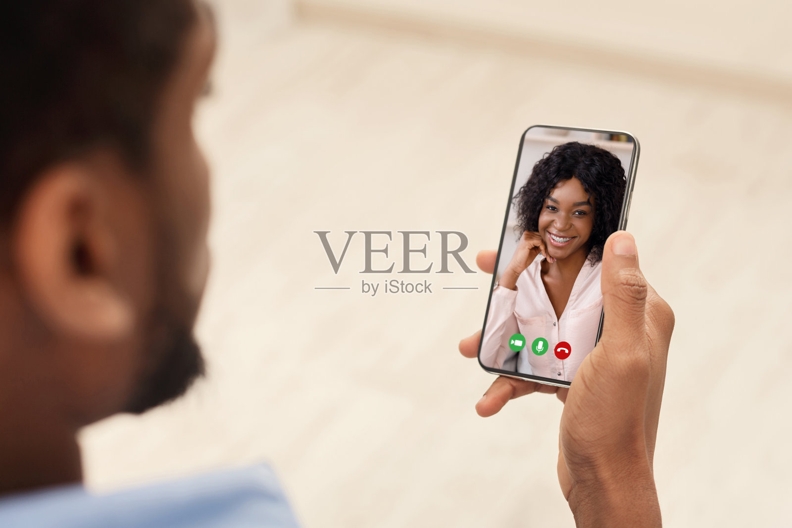 一个非裔美国人在室内用智能手机和女友视频聊天照片摄影图片