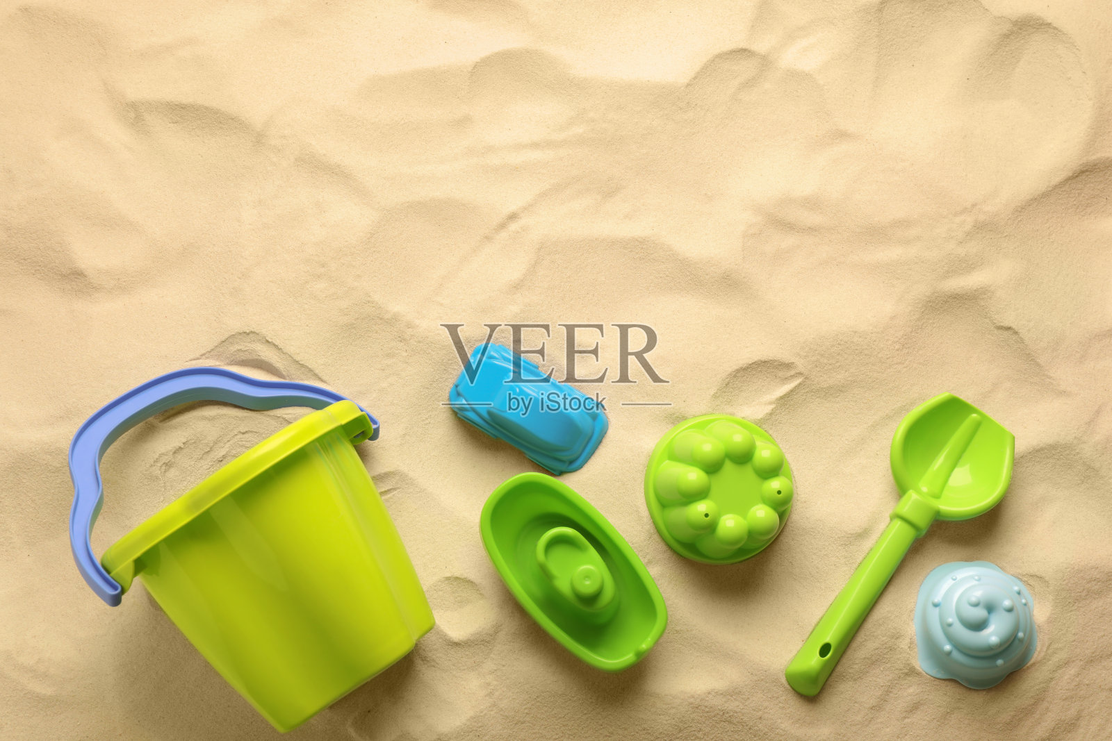 沙滩玩具套件平铺在沙滩上，文字空间。户外玩照片摄影图片