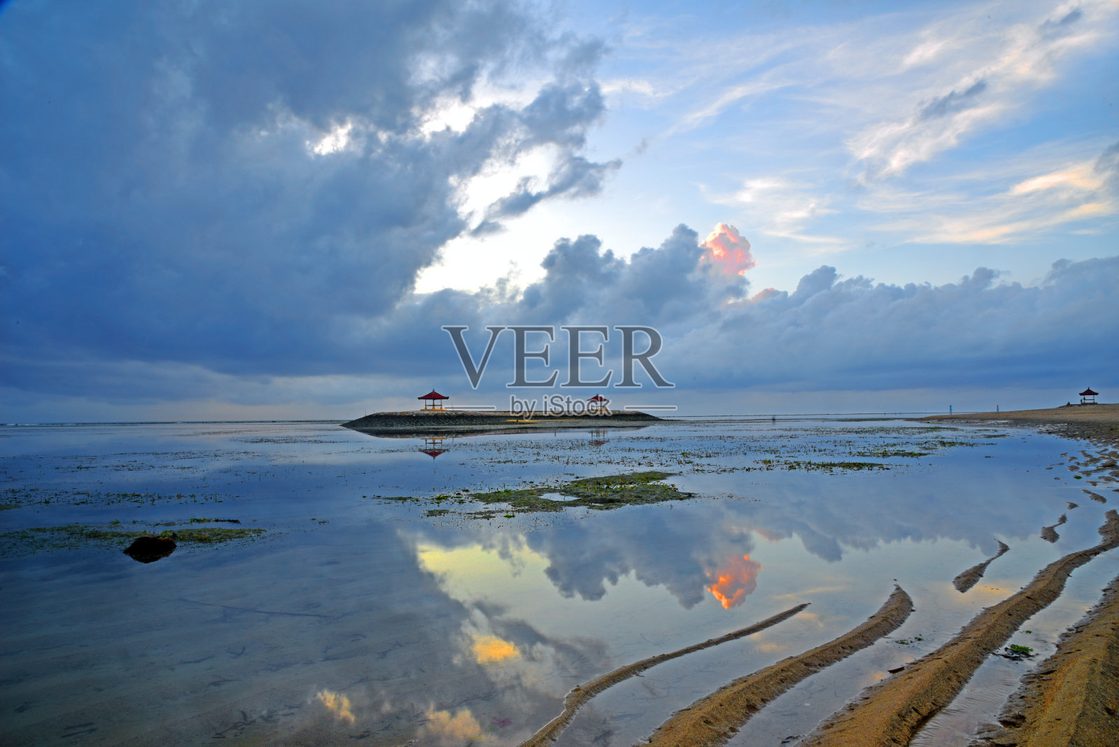 退潮时，太阳在印尼巴厘岛的Sanur海滩升起。照片摄影图片