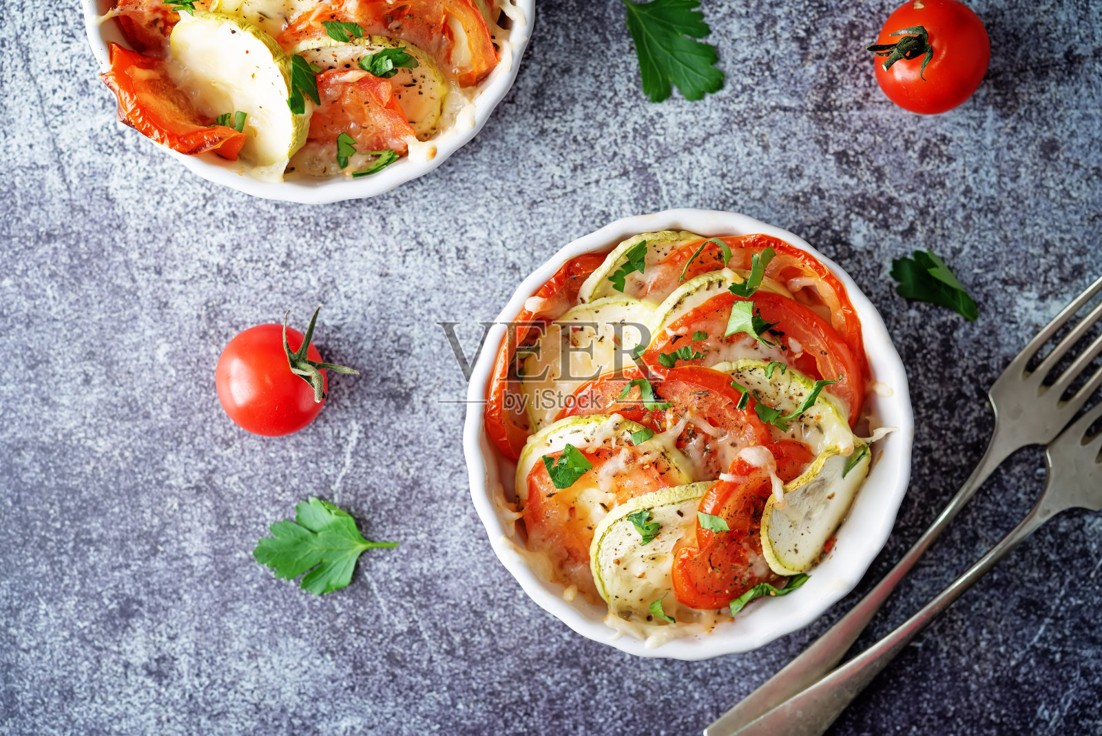 白碗西葫芦番茄砂锅，配胡椒和欧芹照片摄影图片