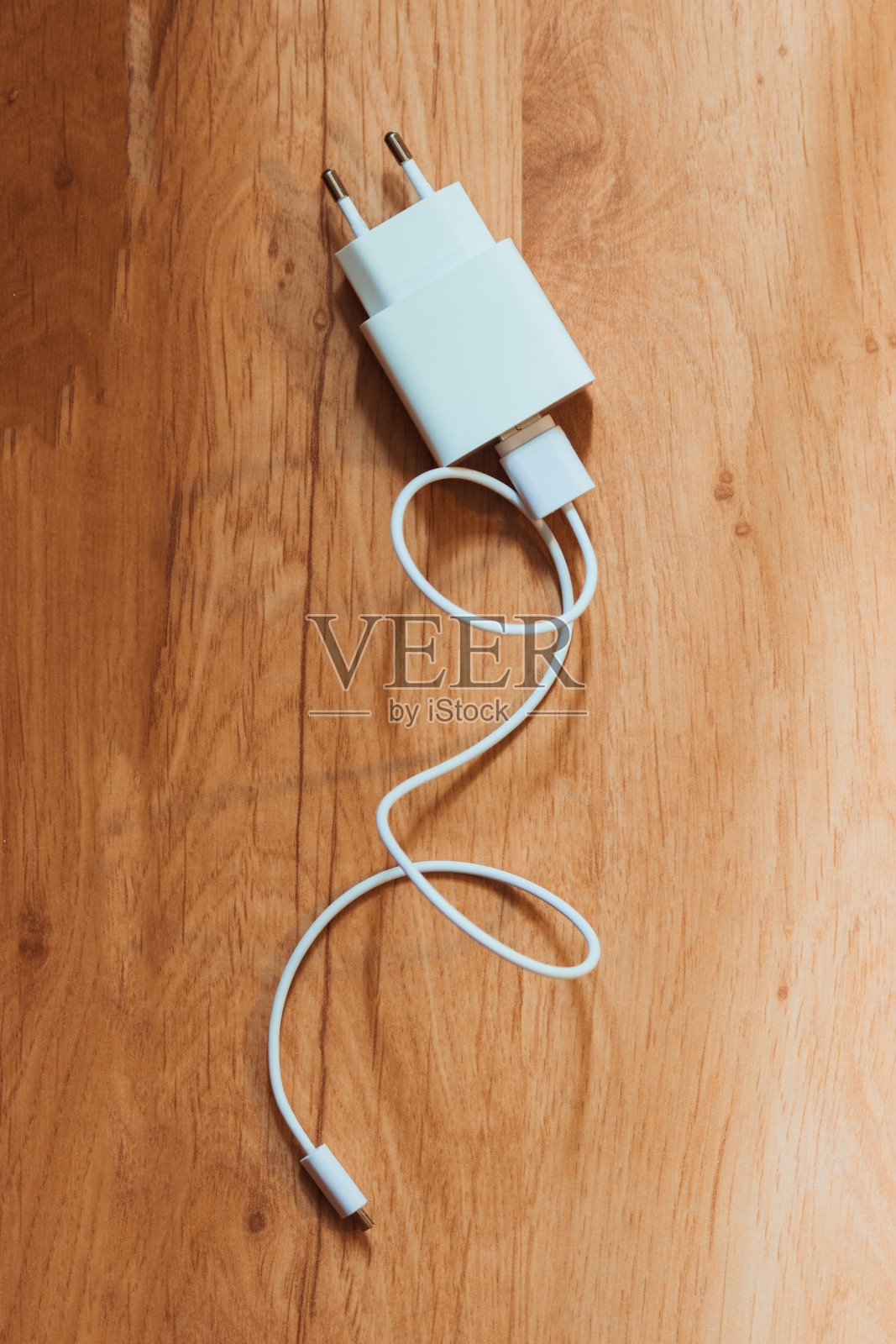 木制背景上的电缆充电器。照片摄影图片