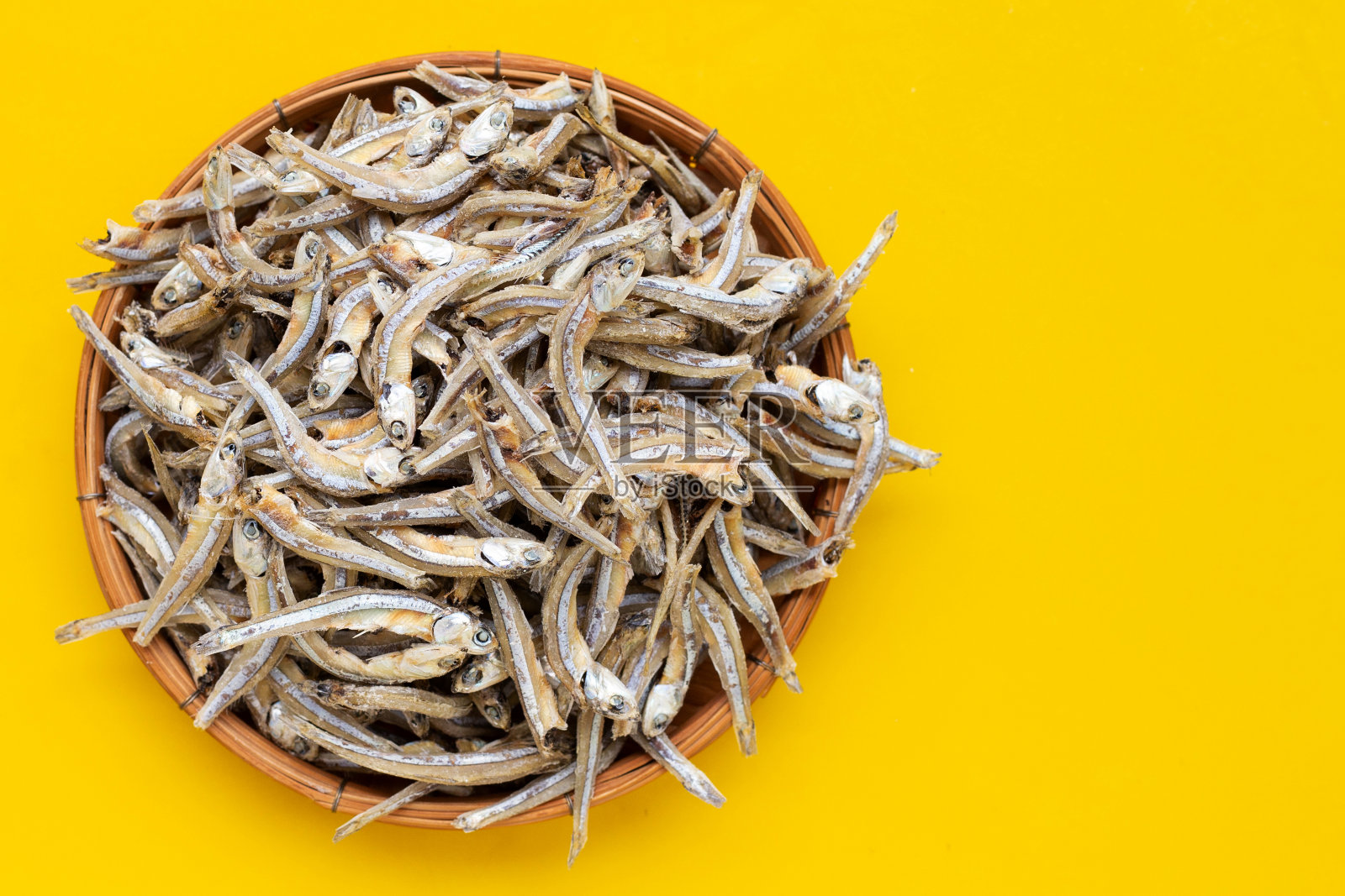 黄底竹篮凤尾鱼干。照片摄影图片