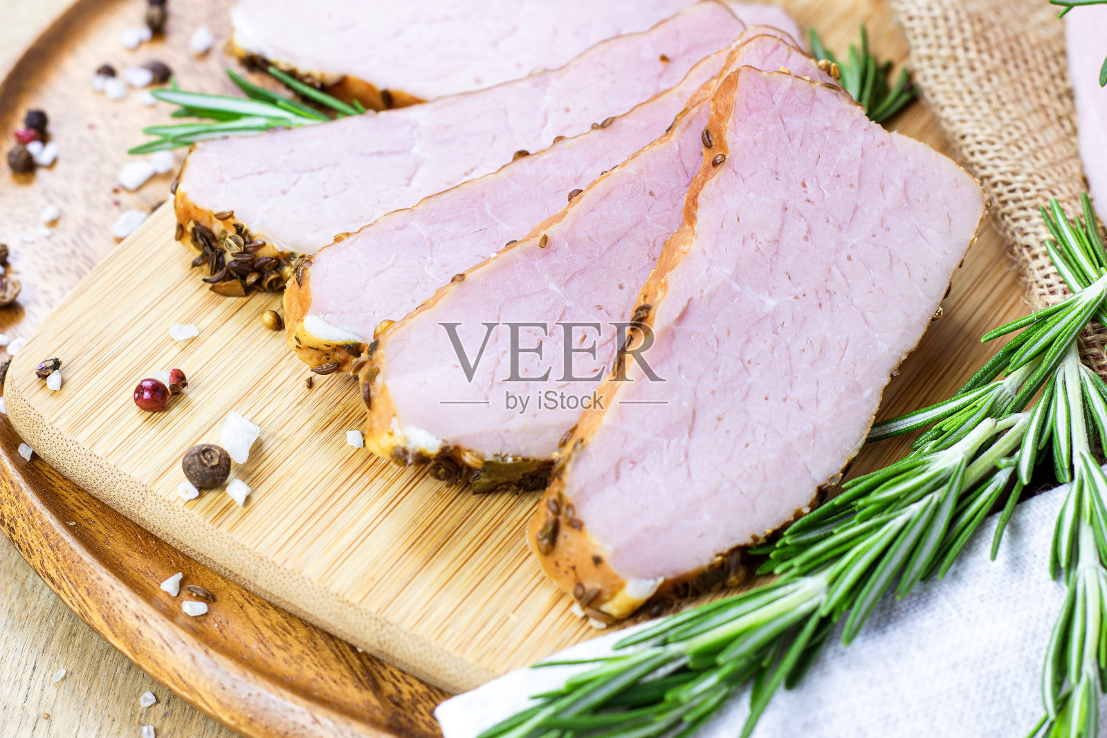 新鲜的烟熏猪肉片晚餐在浅木背景与香料和迷迭香在一边照片摄影图片