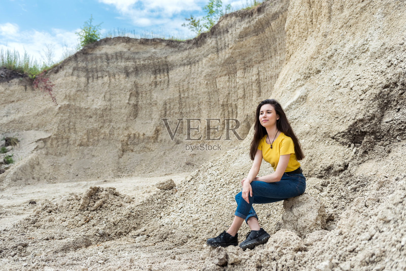 在沙山的背景中摆姿势的女人，夏天的生活方式照片摄影图片