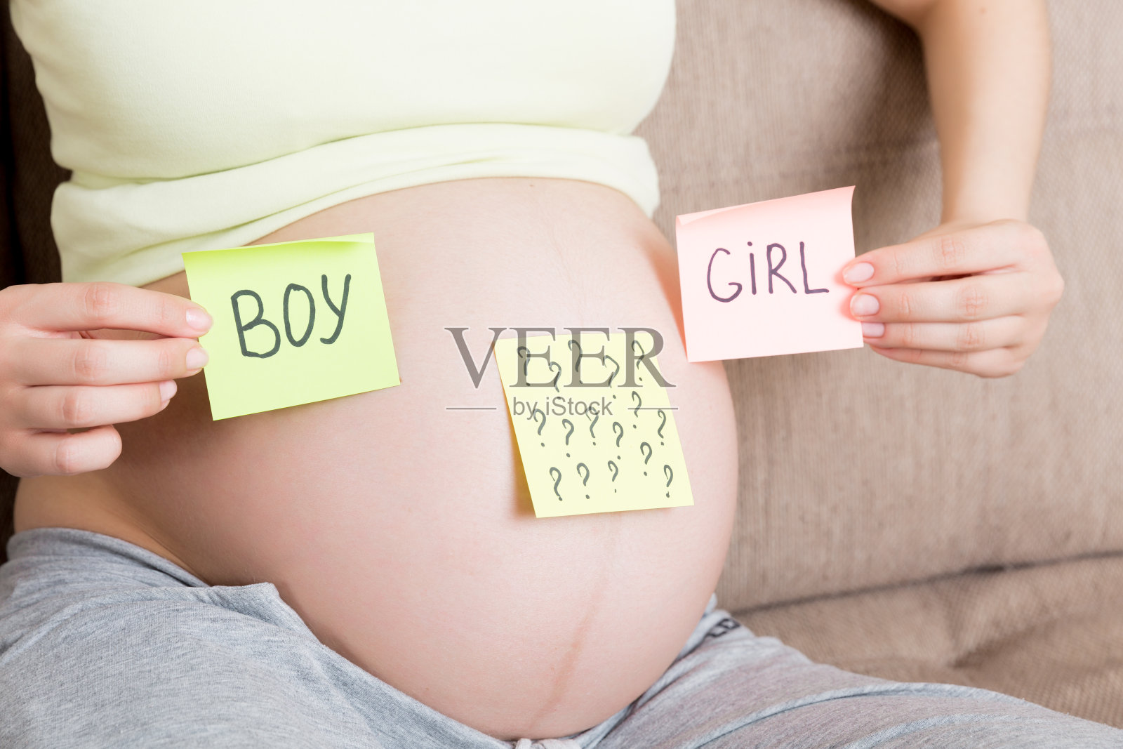 一名孕妇拿着带有问号的方形彩色贴纸照片摄影图片