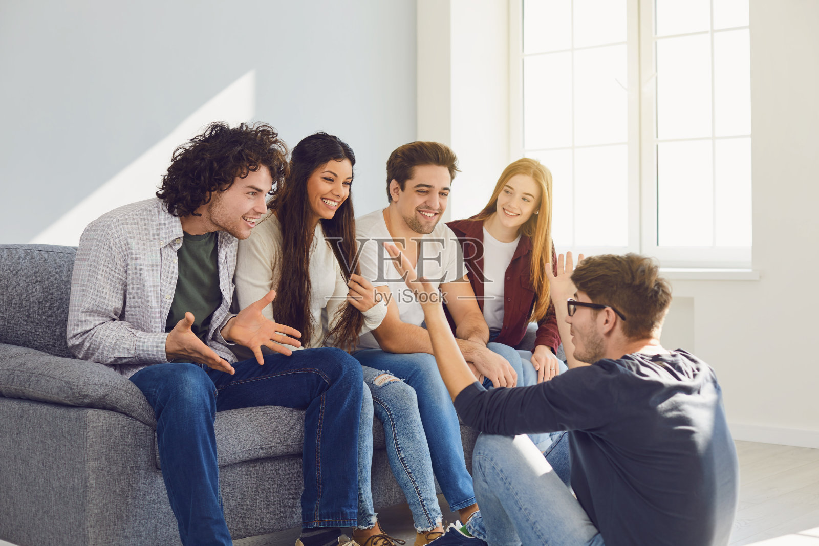 一群朋友在房间里聊天。照片摄影图片