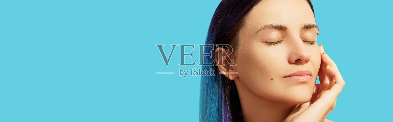 年轻美丽的女人的脸与蓝色的头发在明亮的背景照片摄影图片