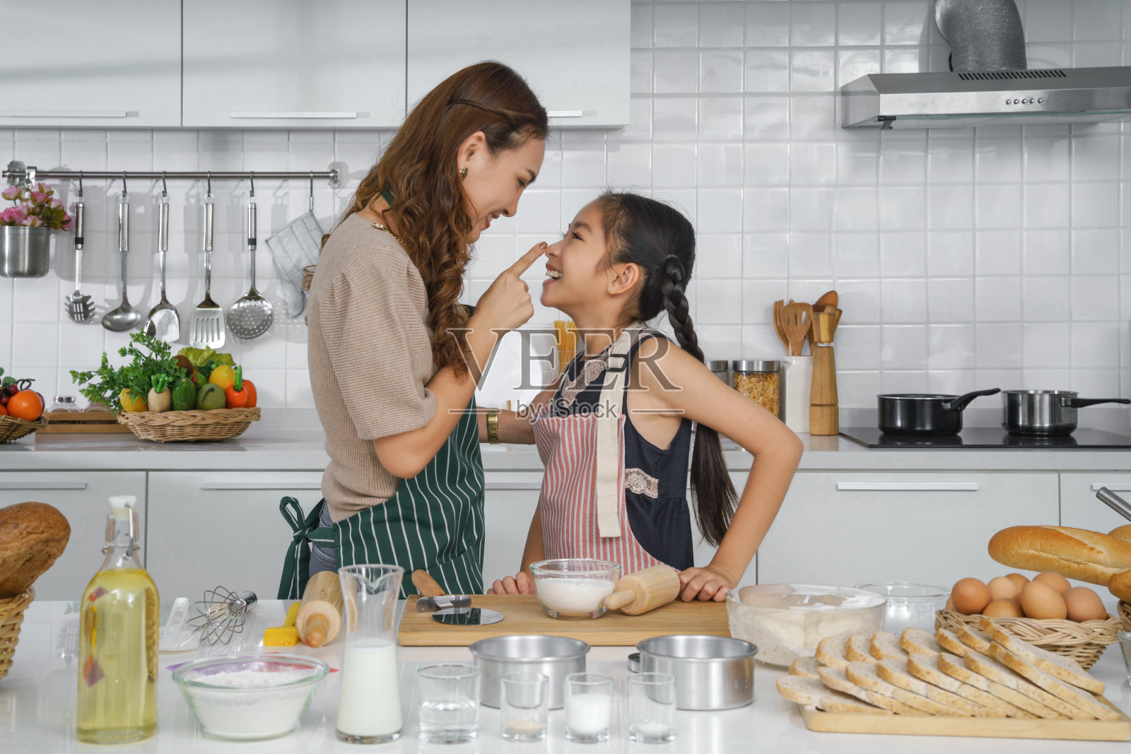 亚洲母亲和小女儿一起在厨房烘焙蛋糕的乐趣照片摄影图片