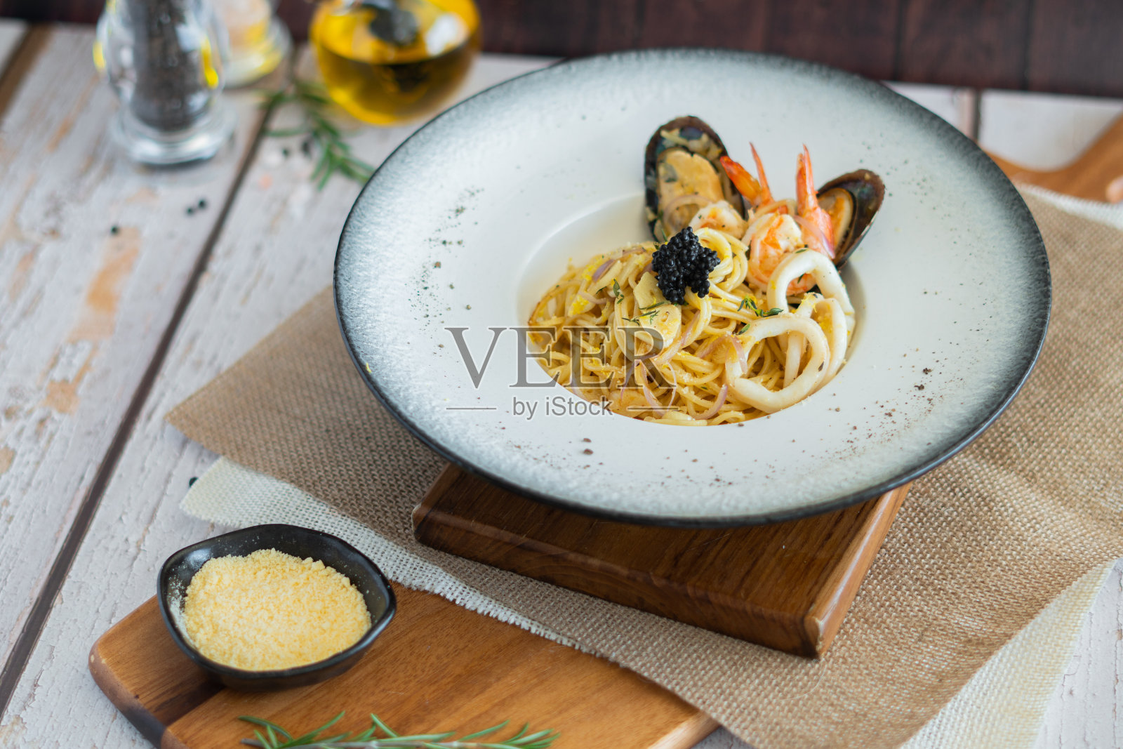 海鲜意大利面加蒜蓉奶酪和白葡萄酒在木板上照片摄影图片