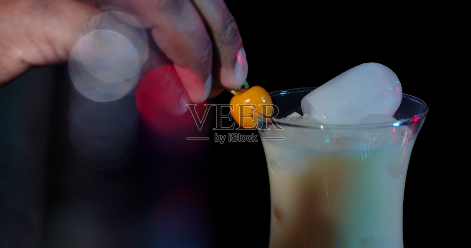 调酒师调制完一杯鸡尾酒。照片摄影图片