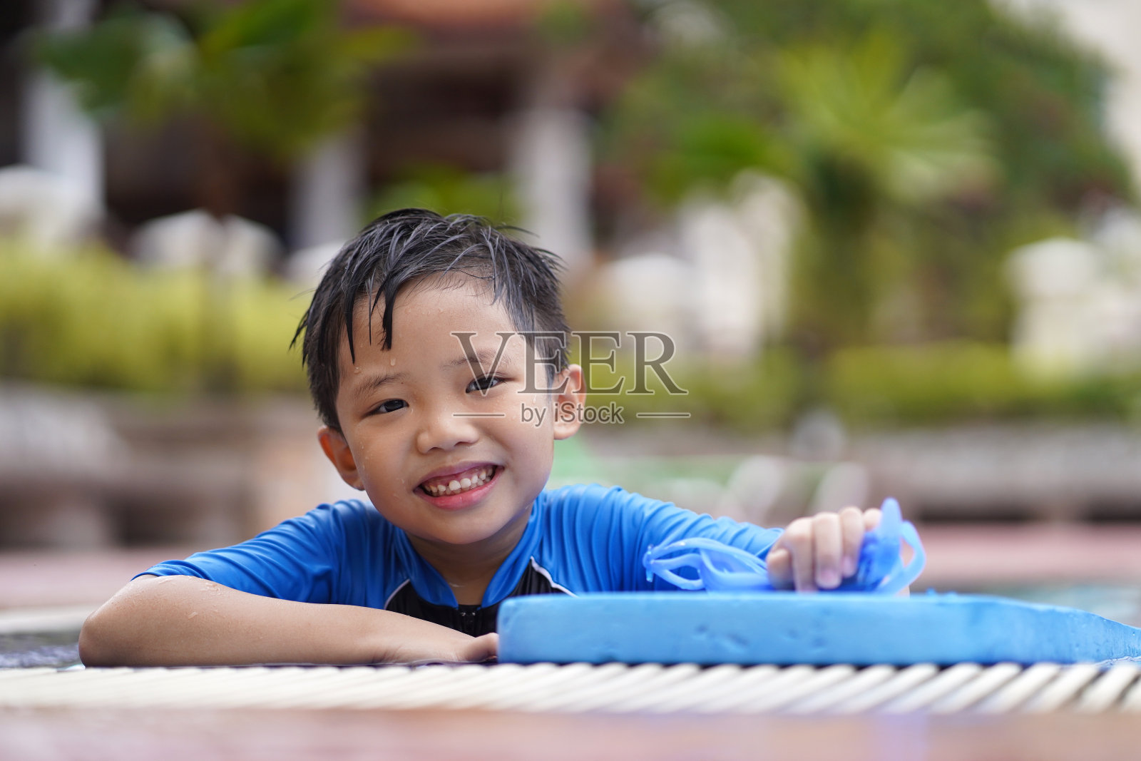 游泳池里的亚洲小男孩照片摄影图片
