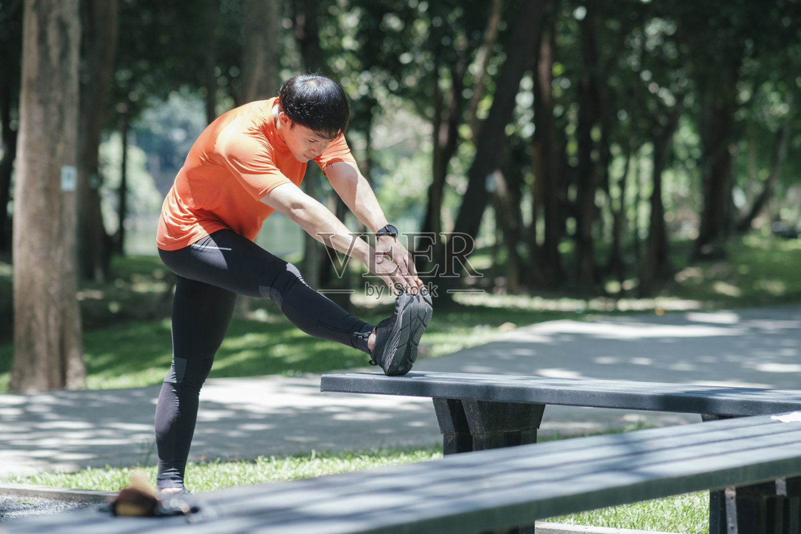 跑步的年轻人在伸展腿。照片摄影图片