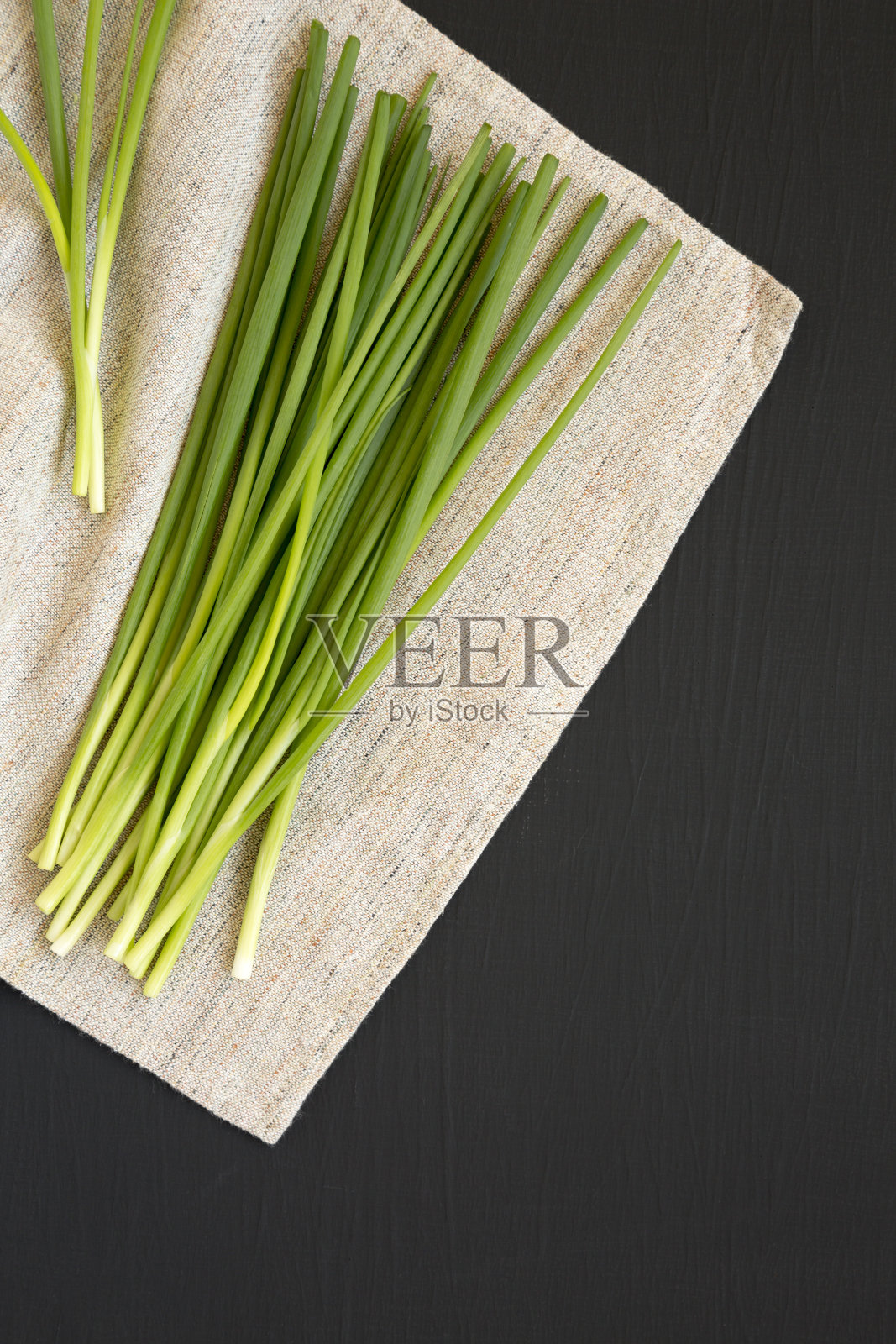 生葱在黑色背景，俯视图。平躺着，从上面俯视。空间的文本。照片摄影图片