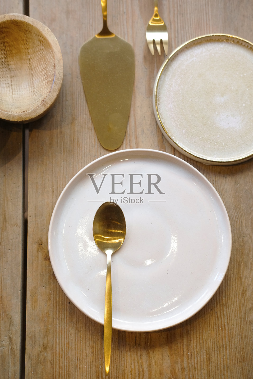 金色的厨房陈设在木桌上。白色的盘子照片摄影图片