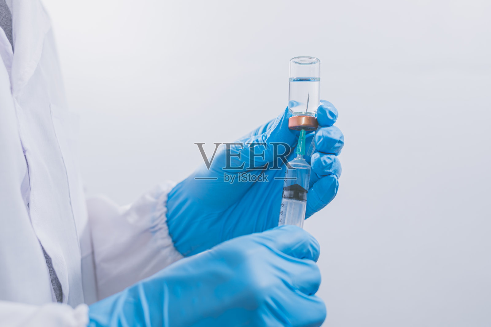 医生或科学家正在使用疫苗对抗COVID-19或相信其他疾病。照片摄影图片