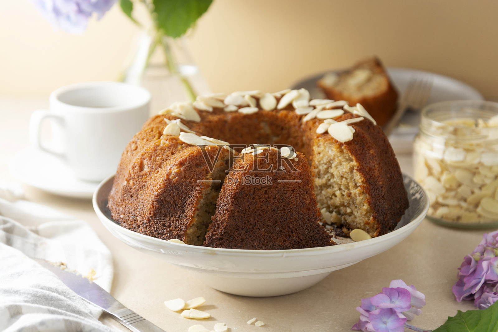 传统的面包蛋糕，自制的糕点烤圆蛋糕与咖啡杯和鲜花的背景照片摄影图片
