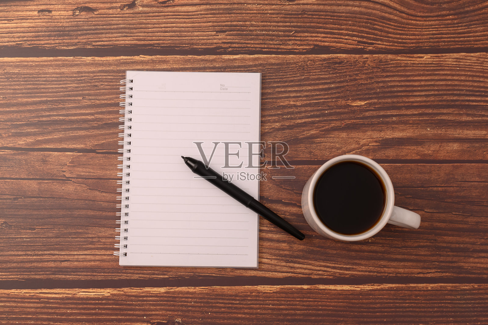 咖啡和笔记本在你的书桌上。照片摄影图片