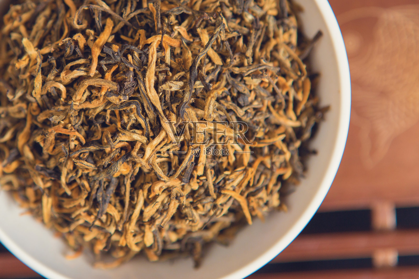 中国茶道。陶土制成的茶壶和木制背景的碗。照片摄影图片