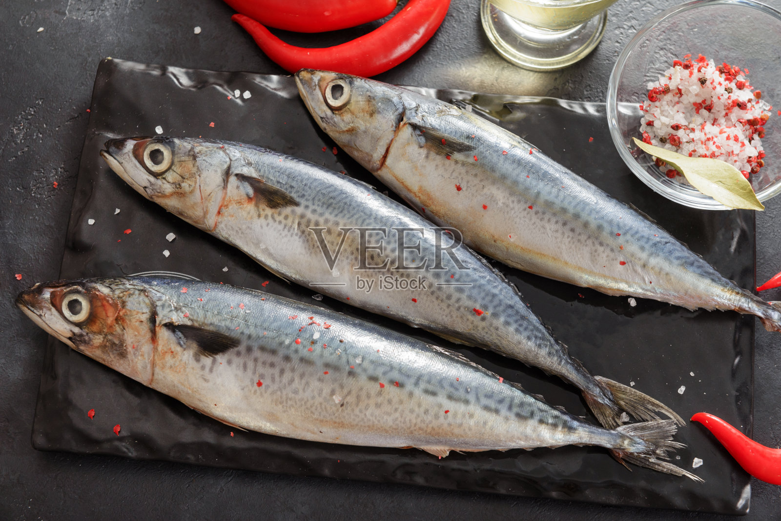 3生鱼，鲭鱼盐，红辣椒上的黑色背景，海鲜照片摄影图片