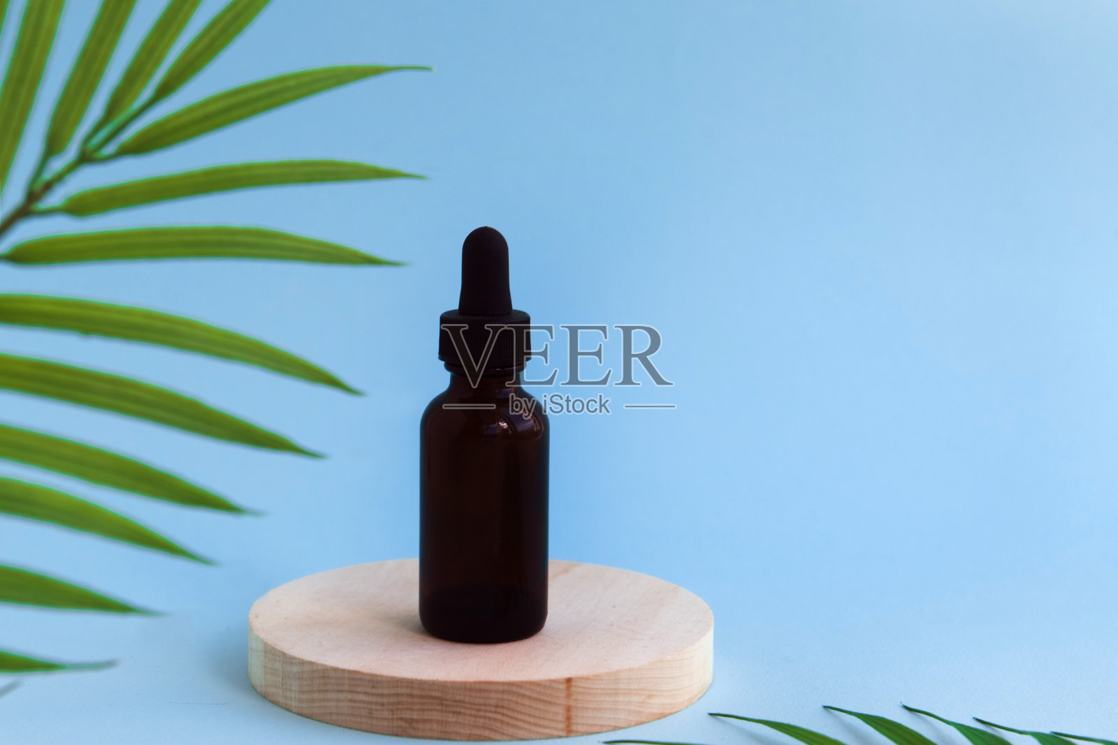 瓶子与化妆品或保健品木制圆形讲台蓝色背景照片摄影图片