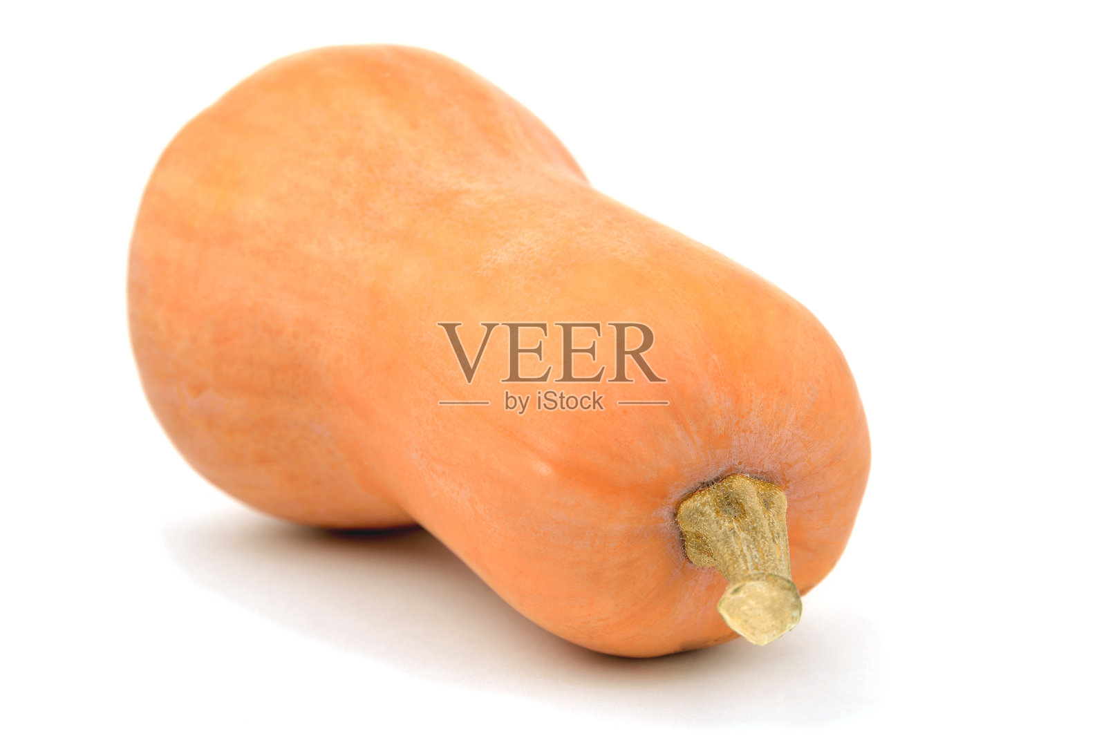 一个梨形的南瓜侧卧在白色的背景上，特写照片摄影图片